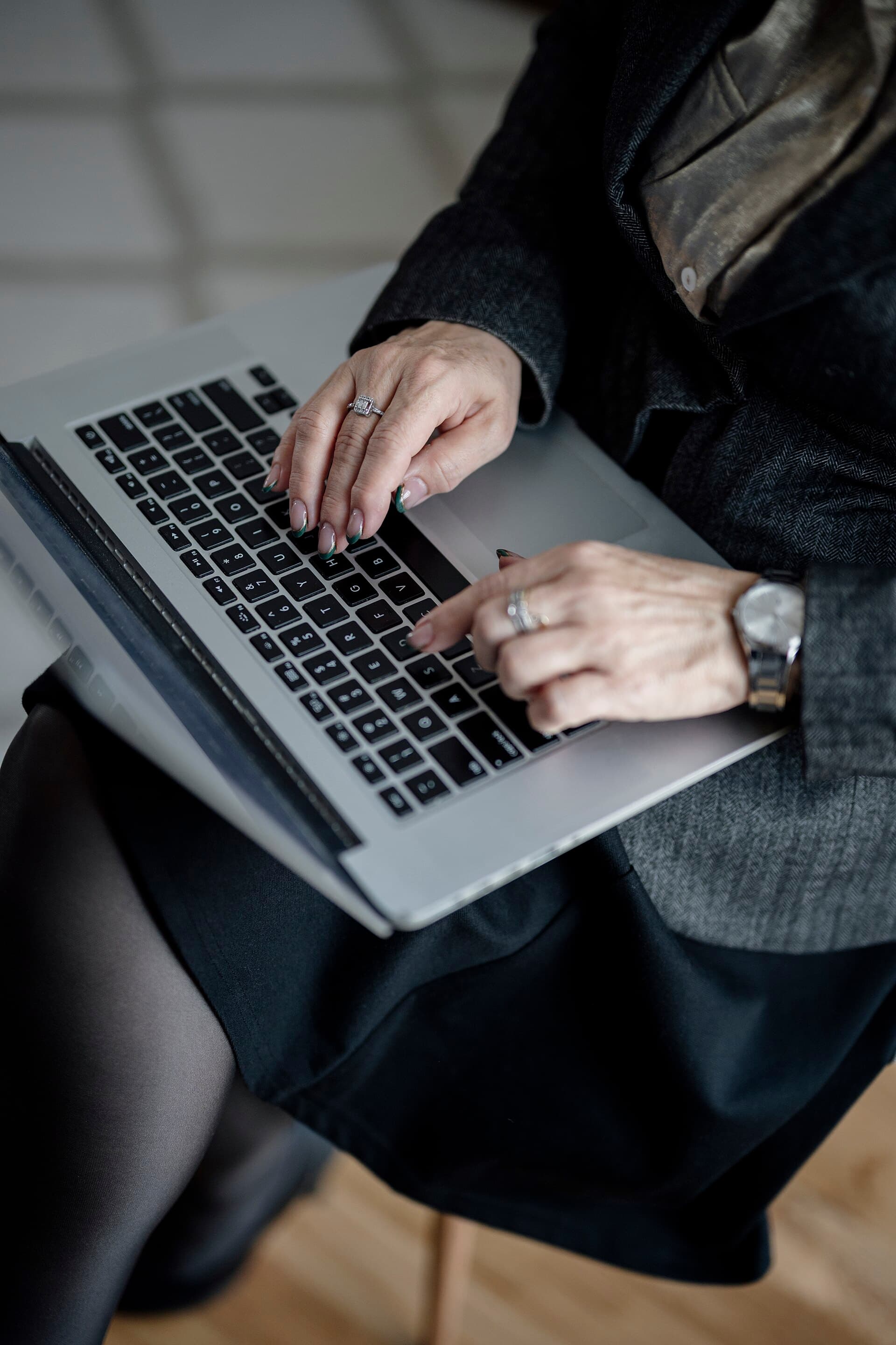 Hands typing on a laptop in a modern office setting